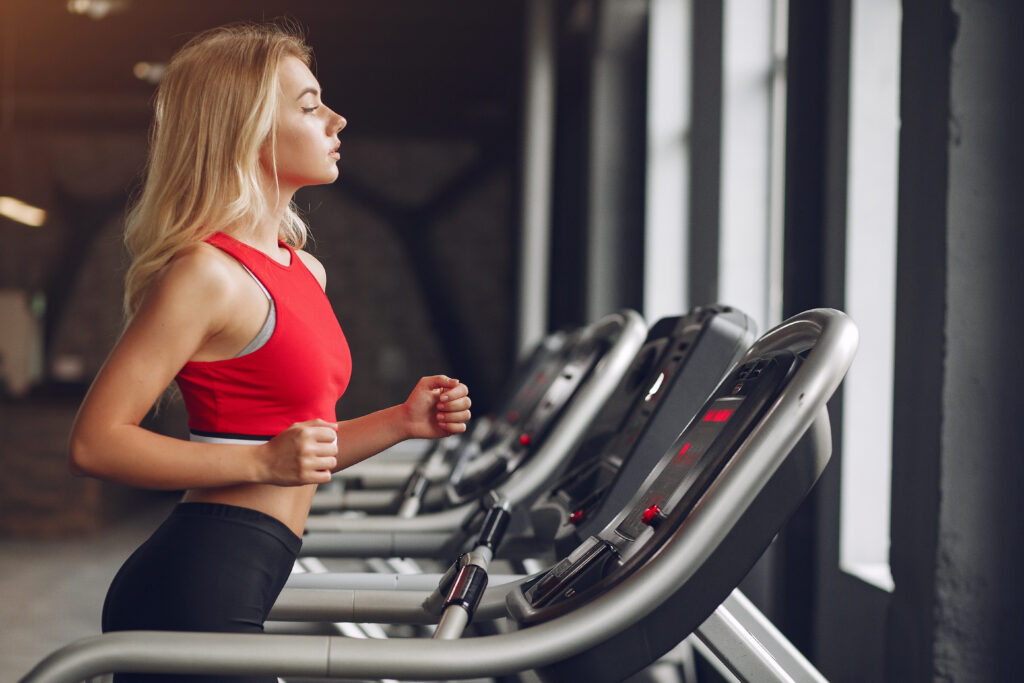 Girl in a gym. Woman on a racetrack. Lady in a red top.